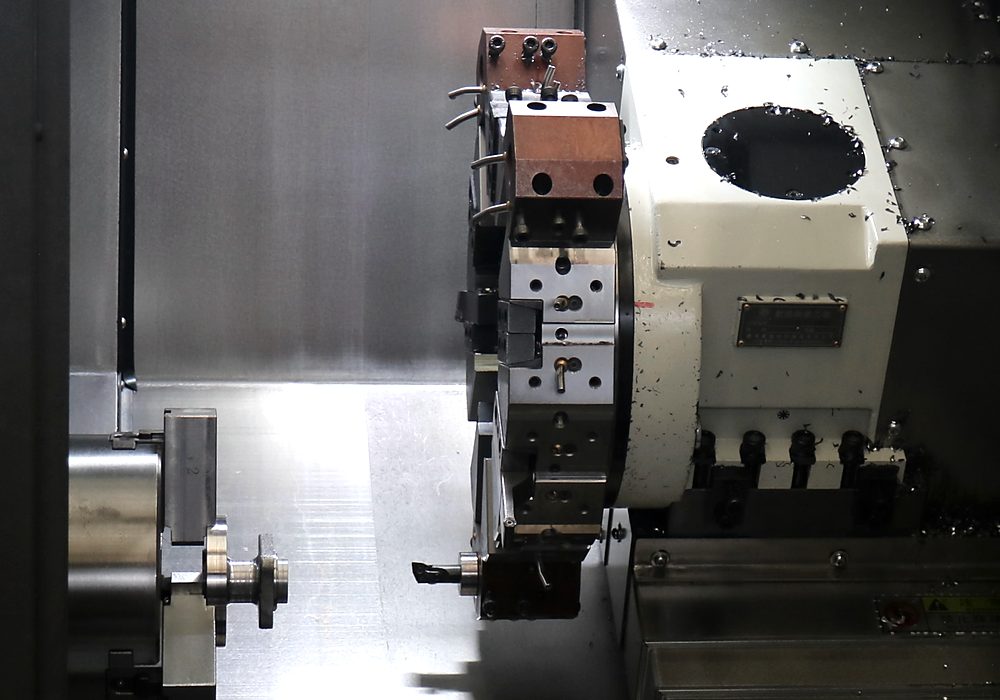 Turning operation on a CNC lathe, swarf curling off the tool.